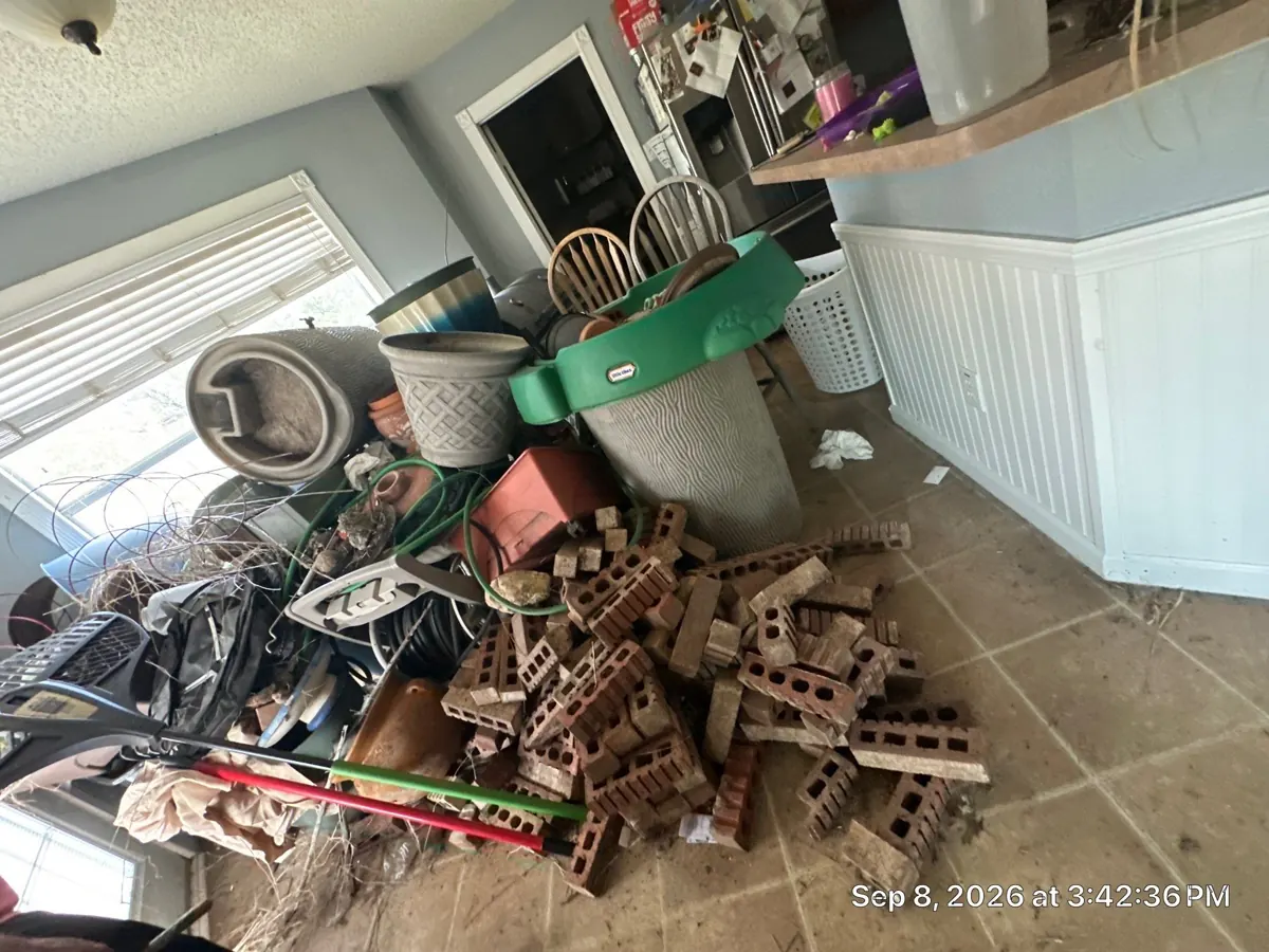 Before: cluttered kitchen breakfast nook filled with furniture, boxes, and household items